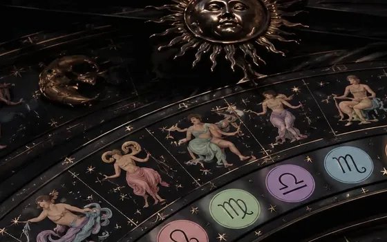 Gilded sun and crescent moon above painted zodiac figures and a ring of pastel sign discs